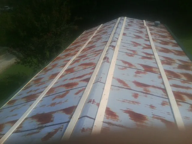 Rusted metal roof panels with new wood purlins before replacement — Storm Damage Roof Repair in Wareham by Roofing Brothers