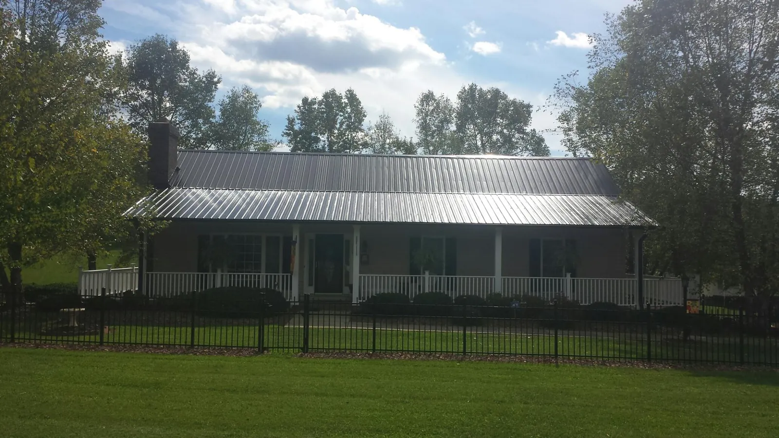 Gray metal roof on a brick ranch with a full width front porch — Gutter Guard Installation work by our crew in Wareham