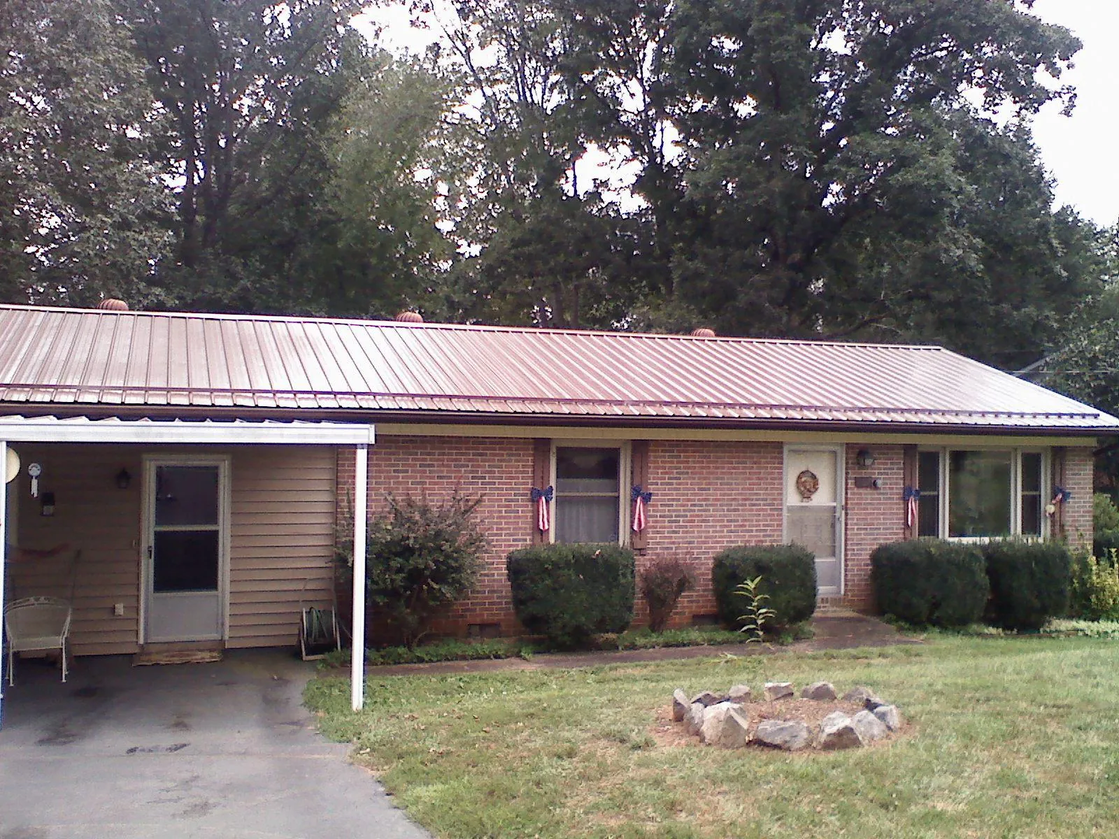 Bronze metal roof and carport on a brick ranch home — Roof Repair work by our crew in Wareham